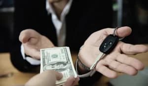 A person receiving cash for their car